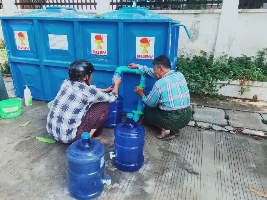 Residents fill drinking water containers from a tank in Pyinmana